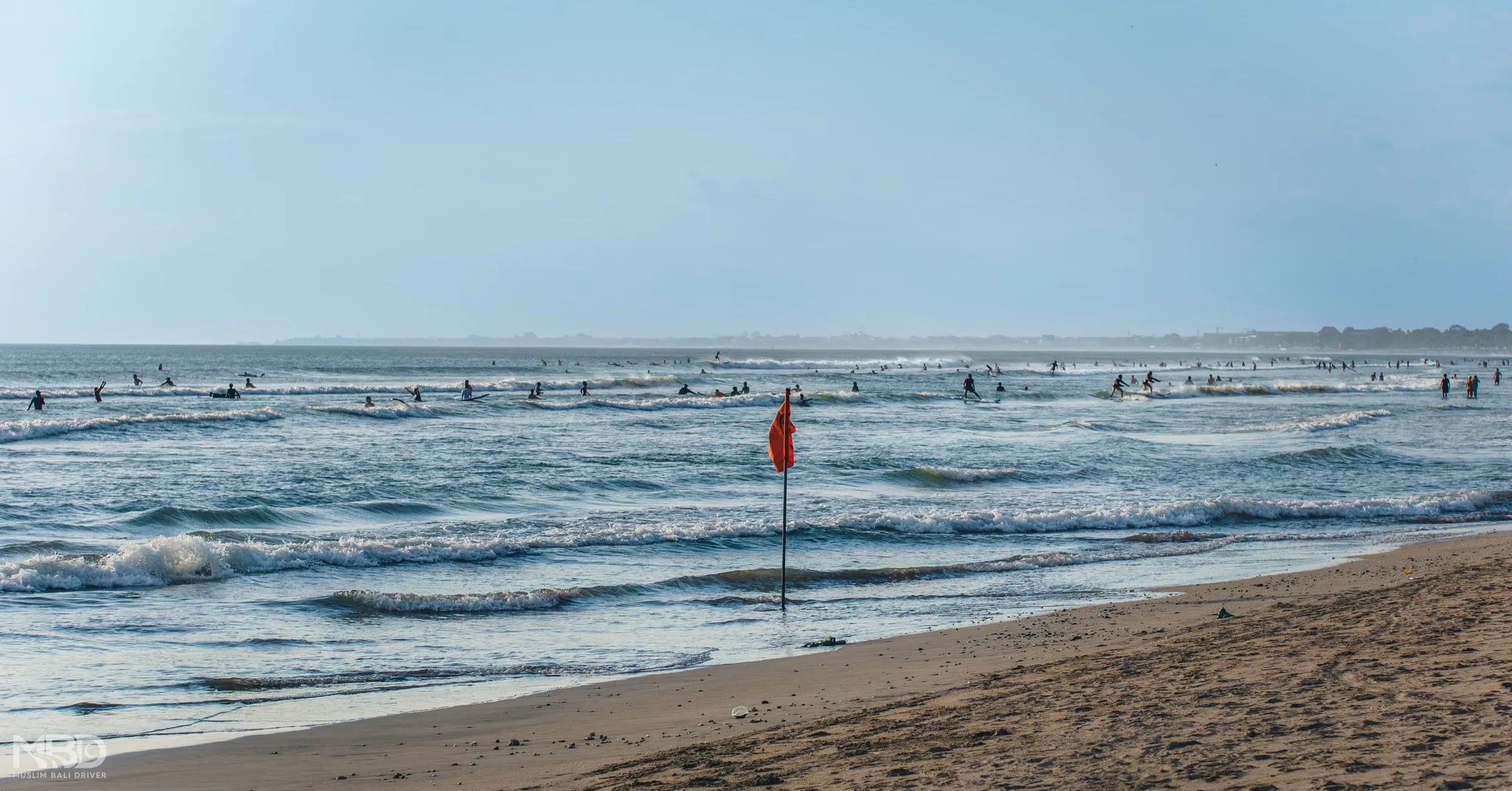 Surfers riding waves at a Bali beach.